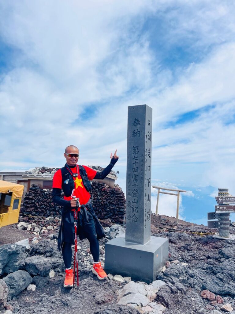 富士山頂の石碑の前のファン・タイ・ヴゥン